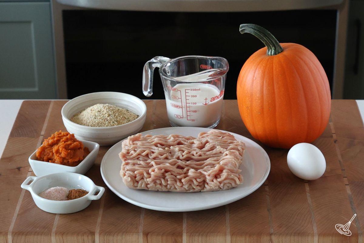 Ingredients to make meatballs including ground turkey, pumpkin puree, and breadcrumbs.