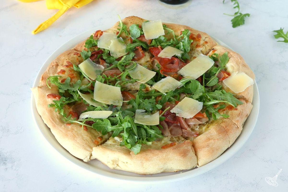 A Prosciutto Arugula Pizza on a platter.