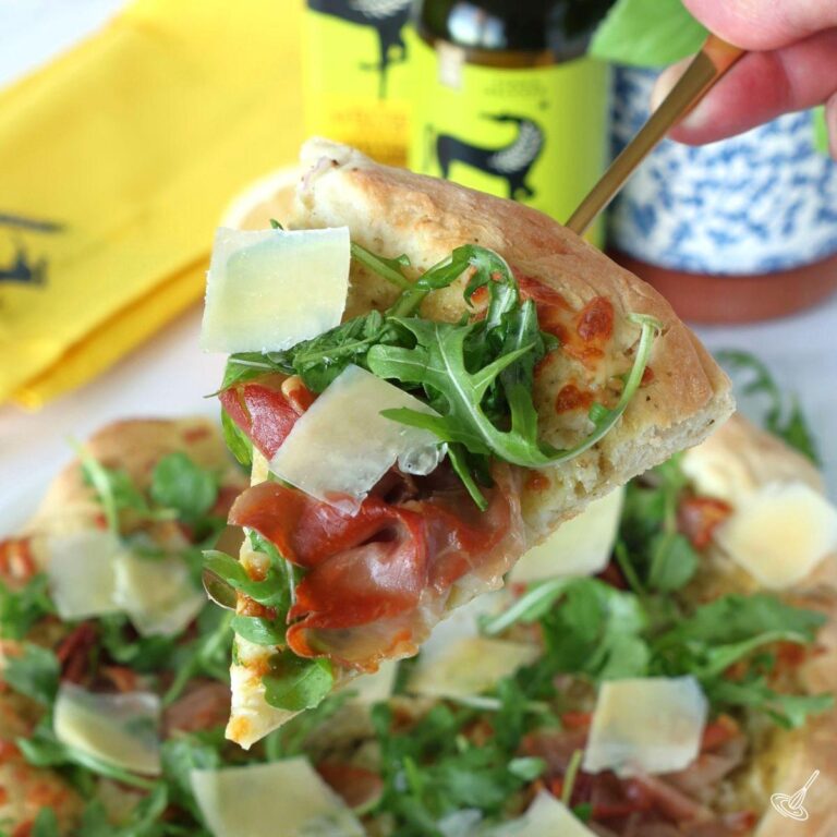 A slice of prosciutto arugula pizza.