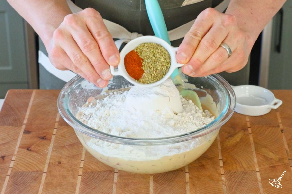 Quelqu’un ajoute les ingrédients secs à une pâte à muffins.