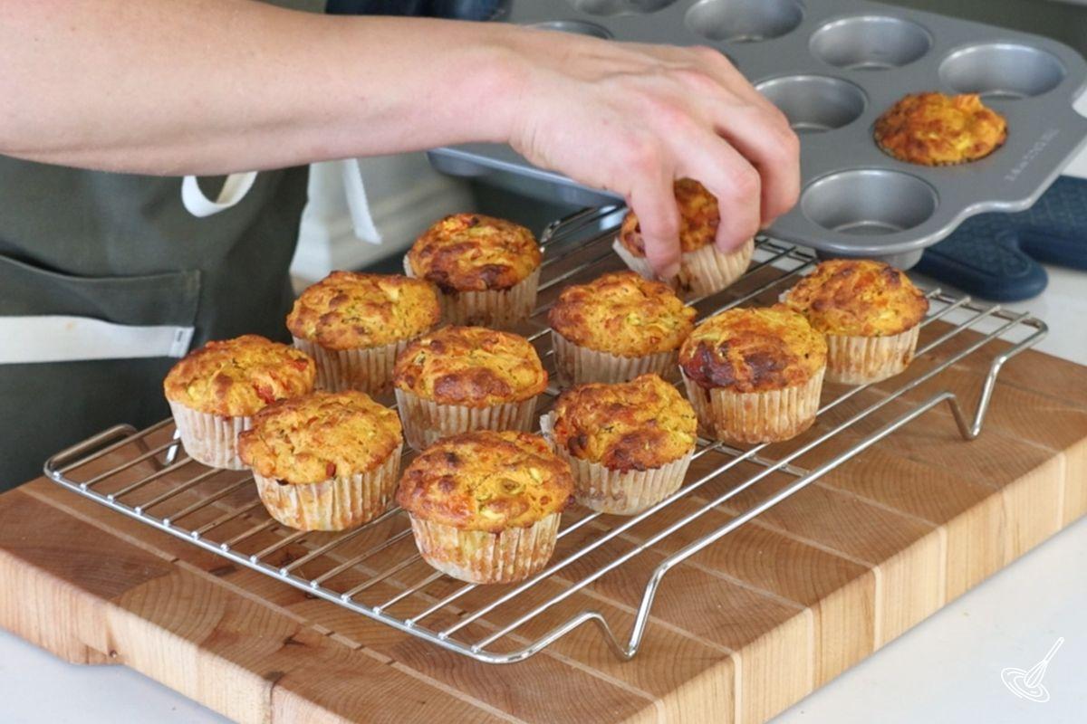 Quelqu’un transfère les muffins cuits sur une grille de refroidissement.