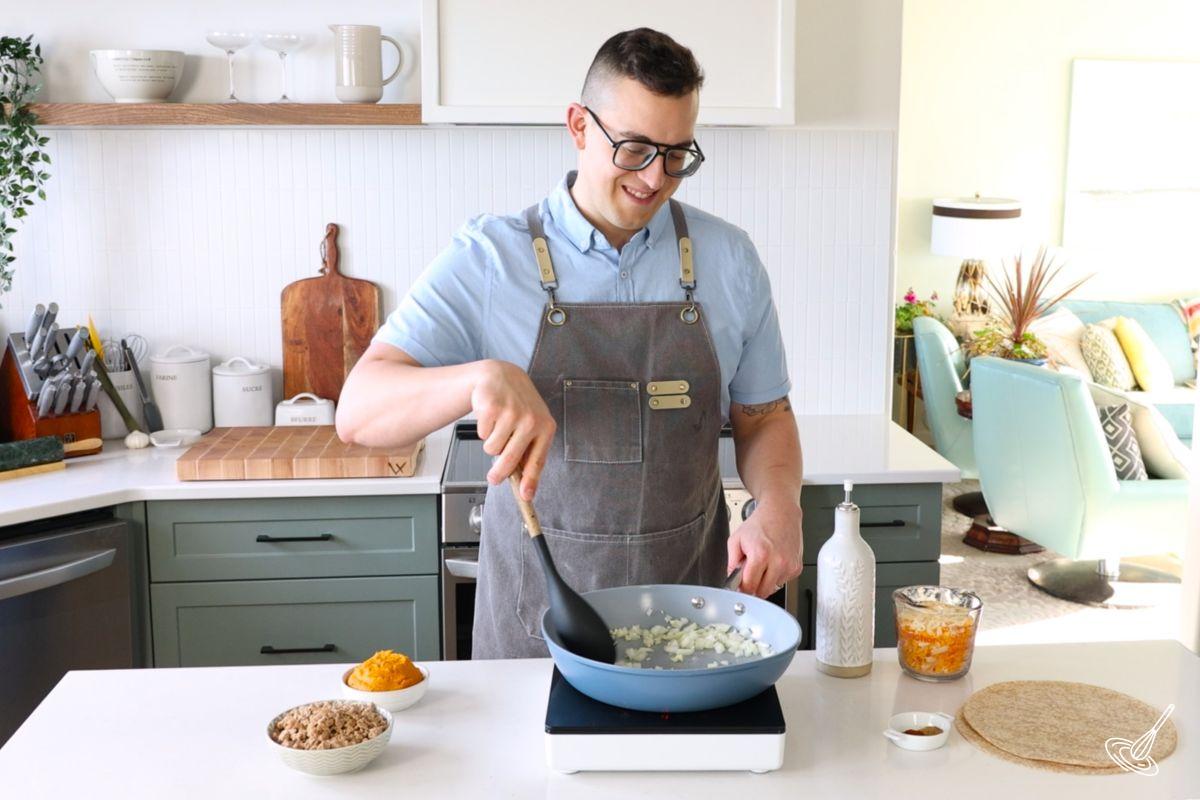 Quelqu’un fait cuire des oignons dans une poêle. 