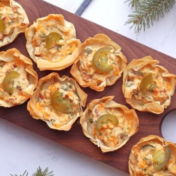 Jalapeño poppers phyllo cups on a serving board.