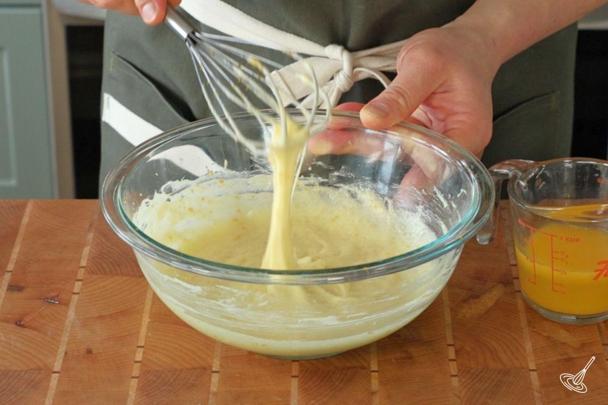 Someone whisking together butter sugar and eggs.