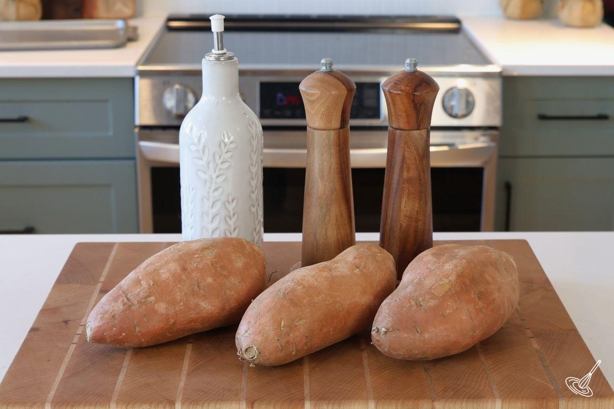 Sweet potatoes on a wooden cutting board.
