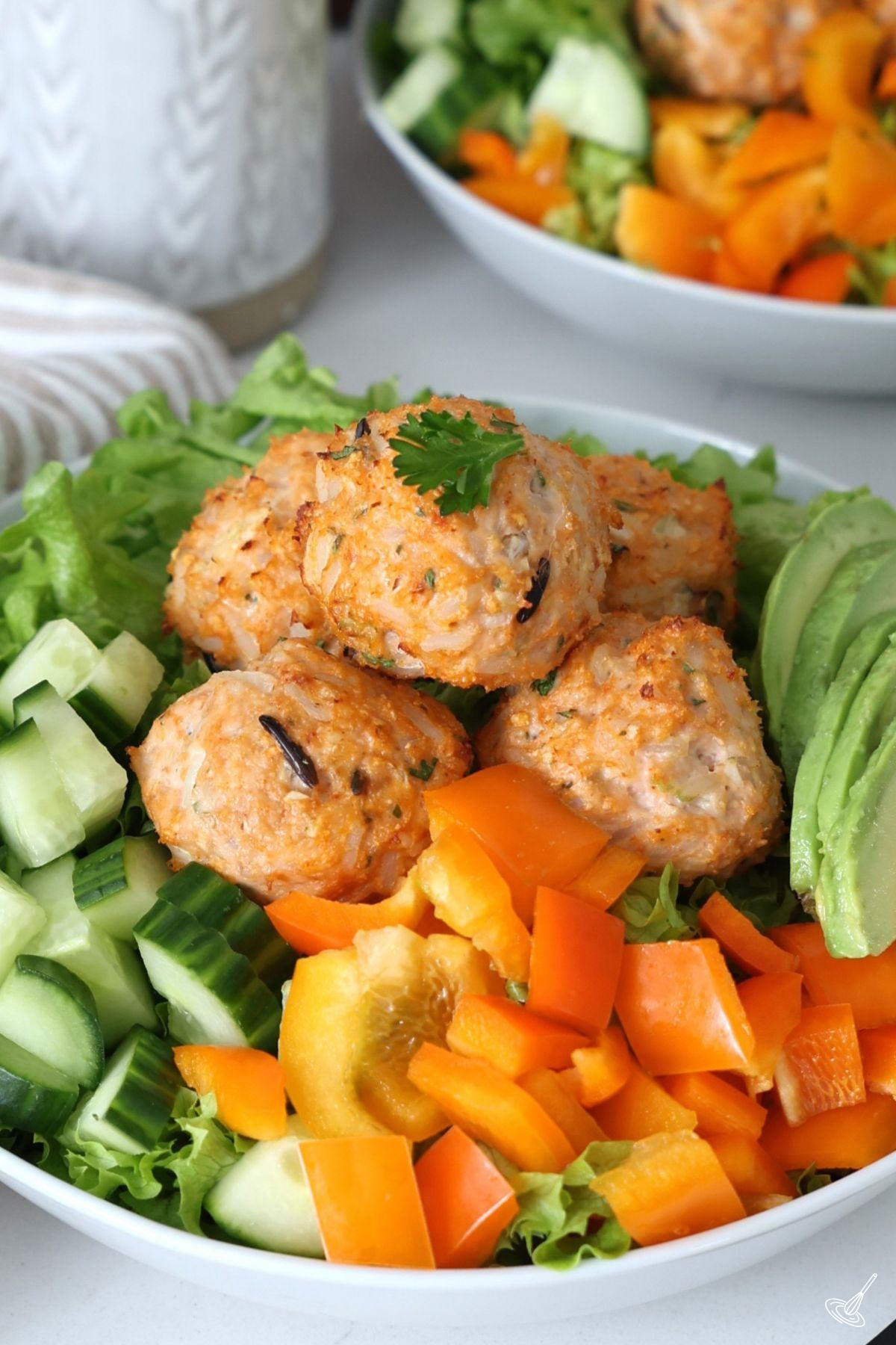 Boulettes de poulet et de riz sur un lit de salade.