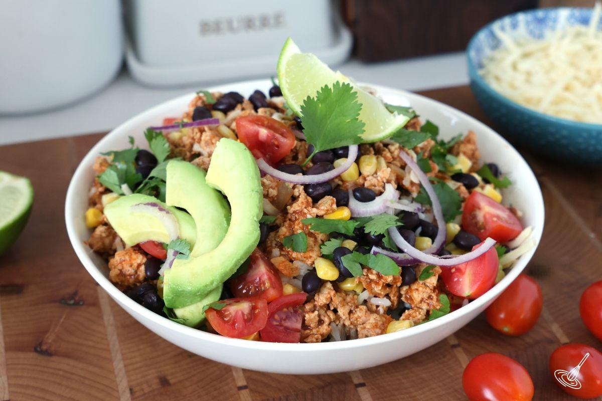 A bowl of Ground Chicken Enchilada with fresh toppings.