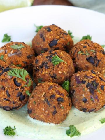Boulettes de patate douce et haricots noirs servies dans une assiette.