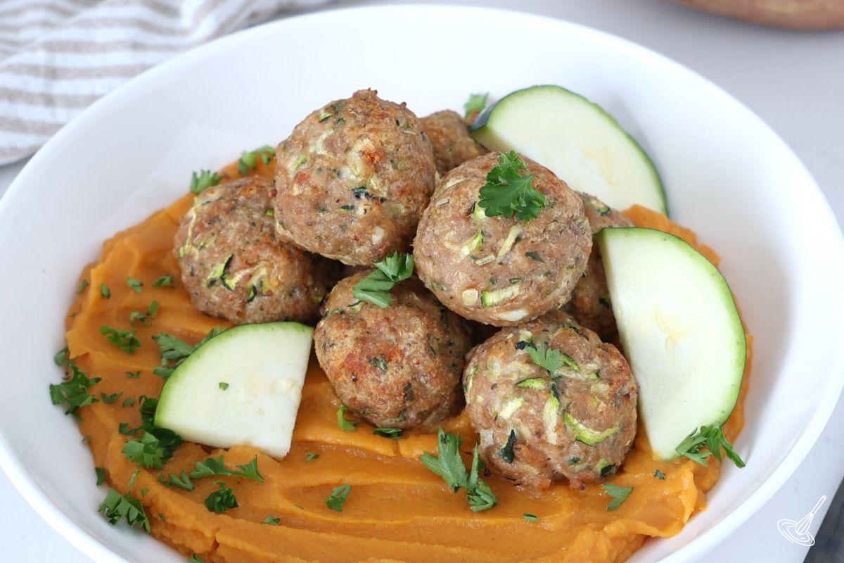 Boulettes de dinde et courgette cuites au four, servies sur une purée de patates douces.
