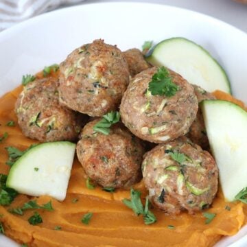 Oven Baked Turkey Zucchini Meatballs served over mashed sweet potatoes.