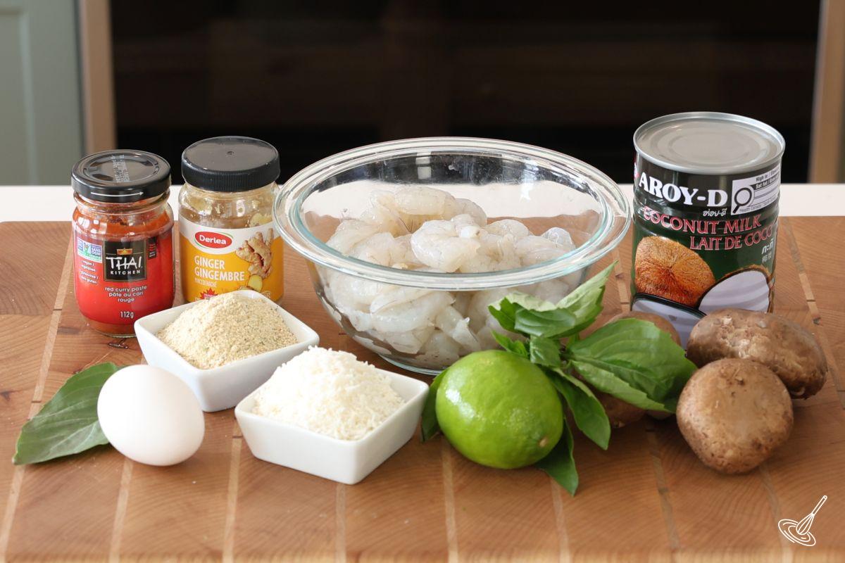 Ingredients on a cutting board, including a bowl of raw shrimp.