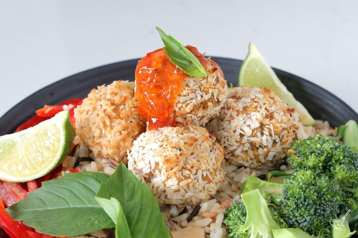 Baked Coconut Shrimp Meatballs served over rice with vegetables.