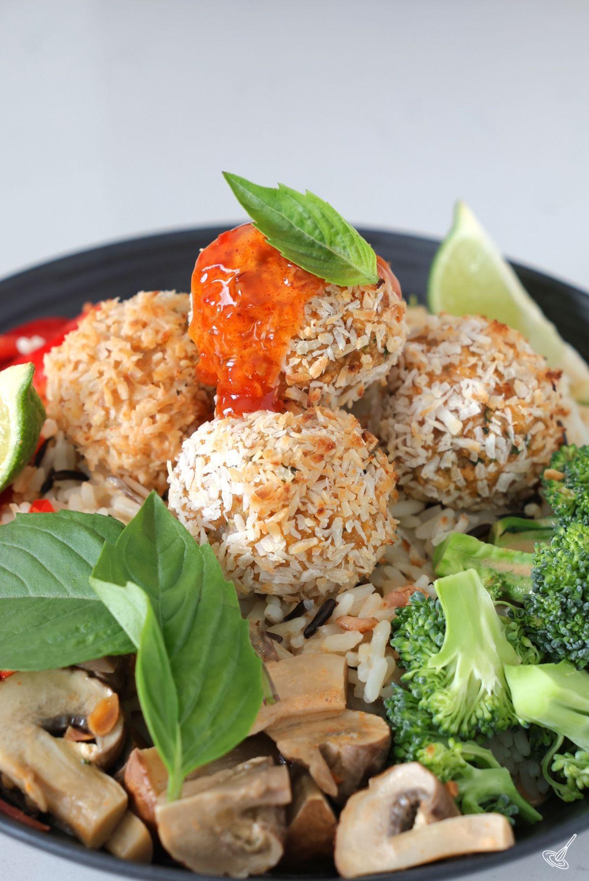 Baked Coconut Shrimp Meatballs served over rice with vegetables.