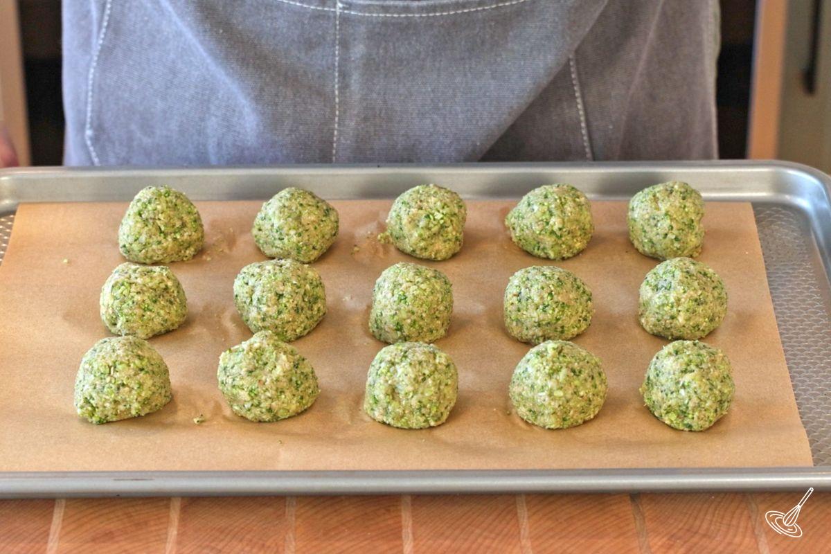 A tray of broccoli parmesan meatballs ready for the oven.