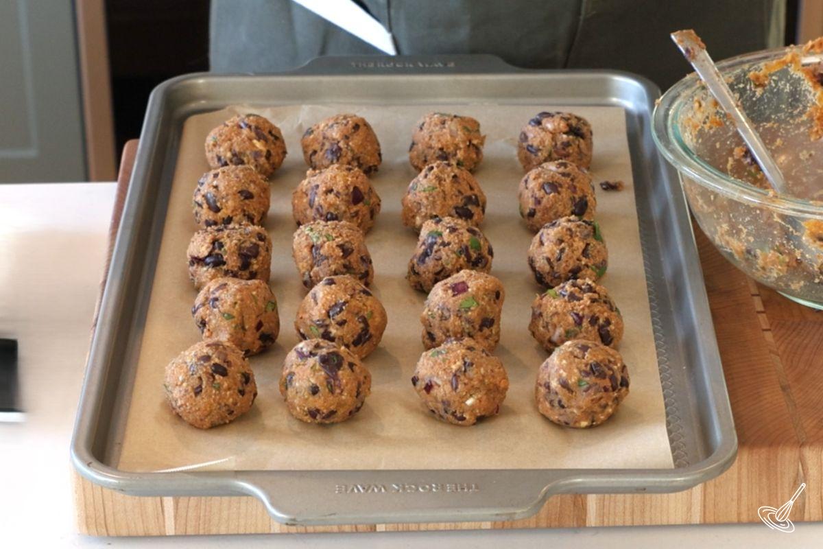 Boulettes de patate douce et haricots noirs sur une plaque de cuisson.