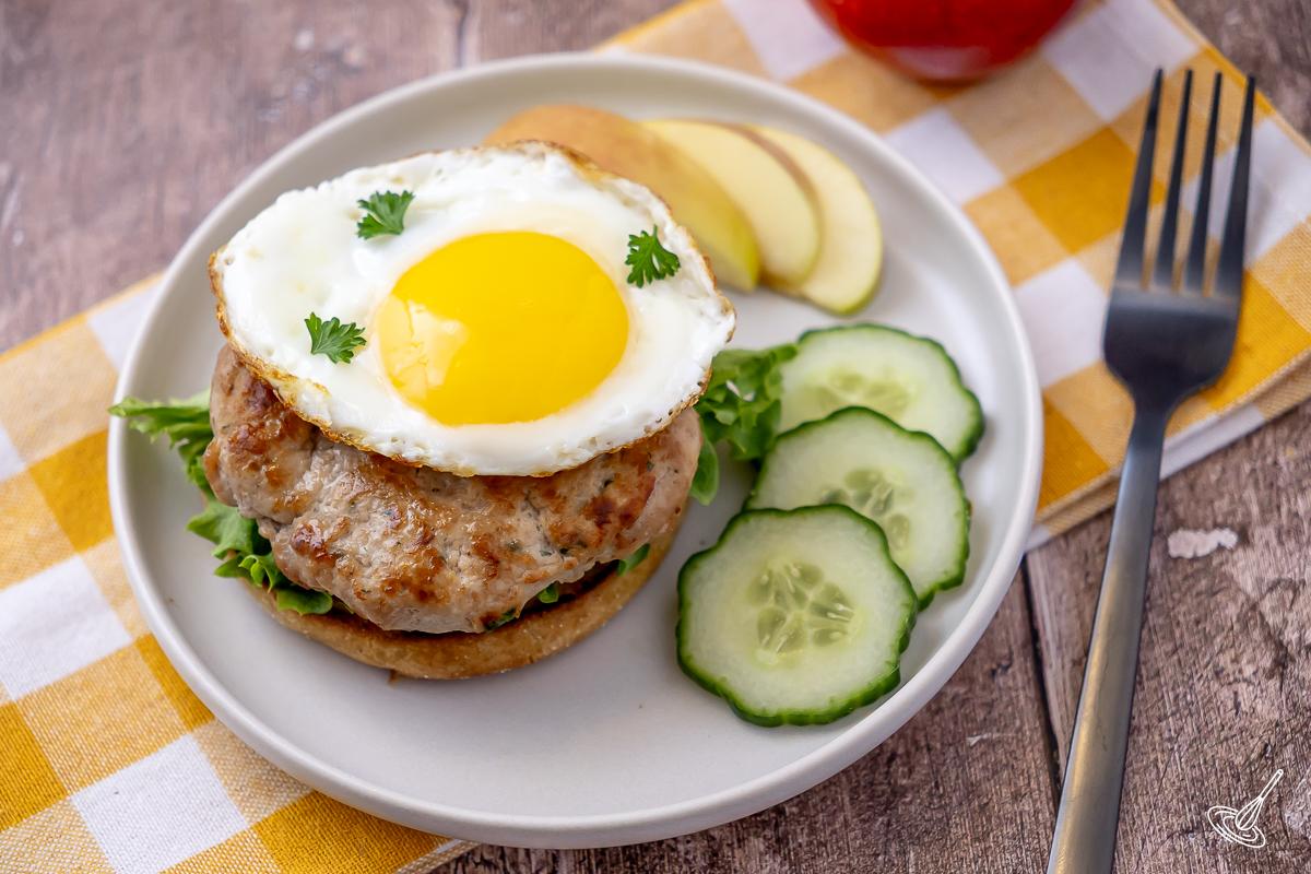 A plate with a breakfast sandwich made with turkey patties.