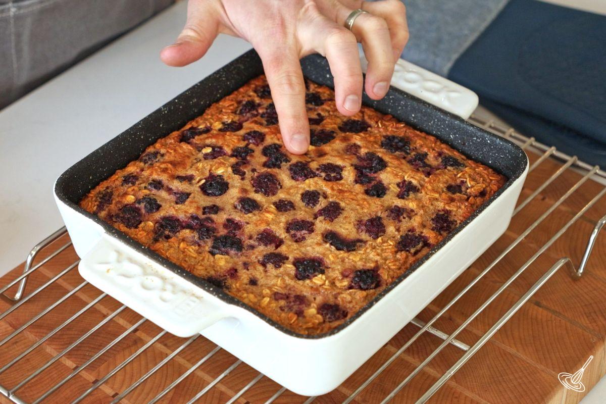 Quelqu'un teste la cuisson du gruau aux mûres cuit au four. 