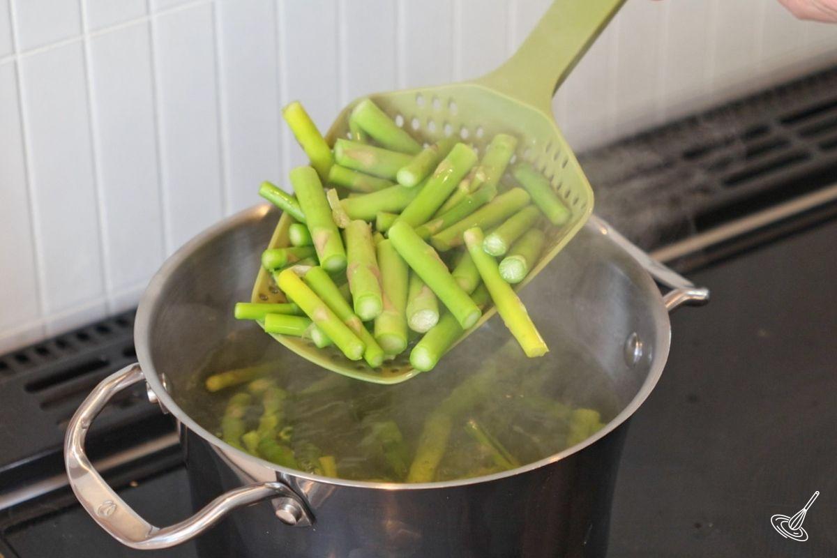 Asparagus pieces blanching in boiling water.