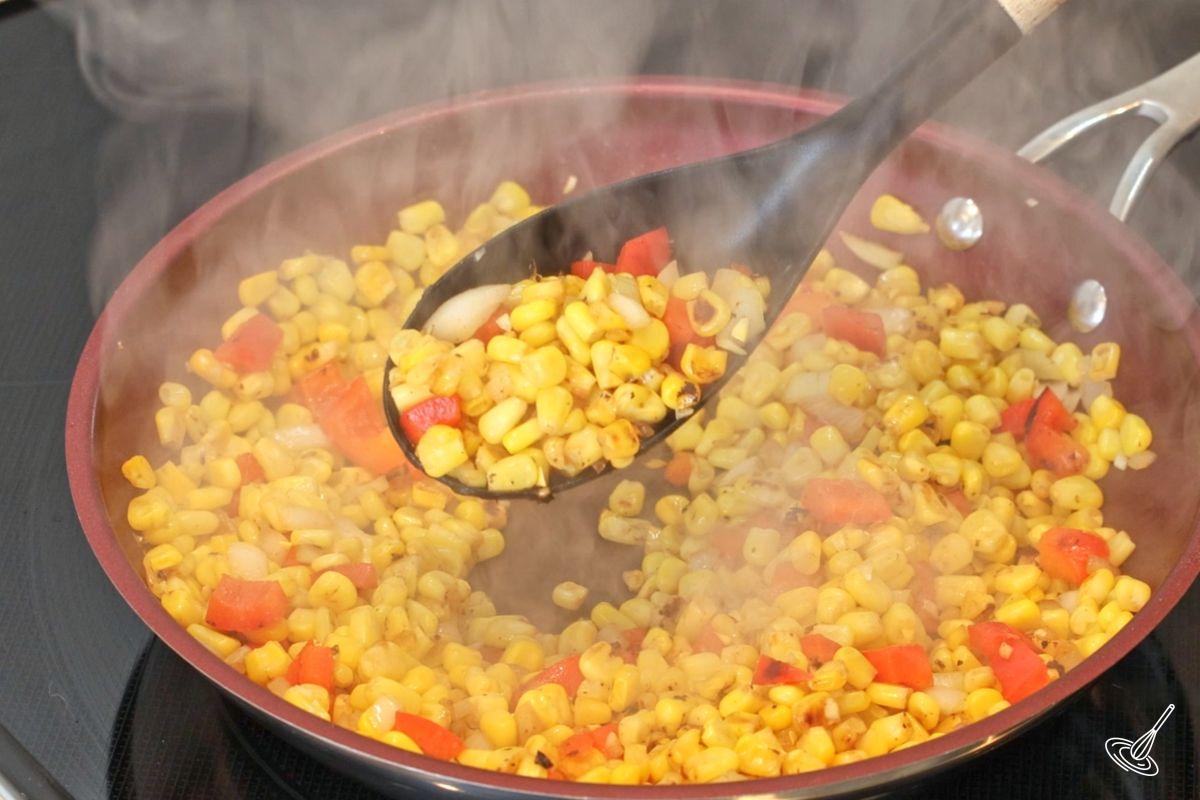 A large spoon of pan roasted corn kernels. 