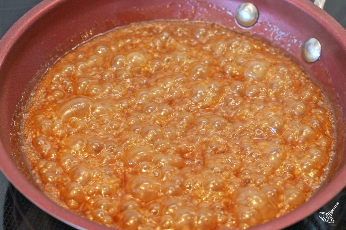 A caramel glaze simmering in a small saucepan.