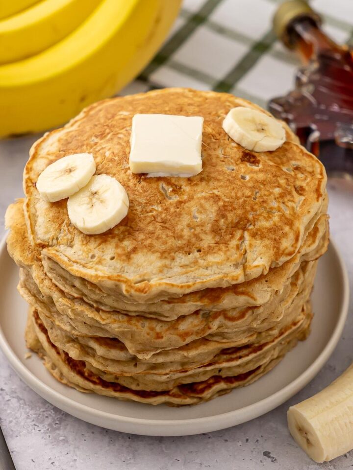 Une pile de crêpes au yaourt grec et à la banane.