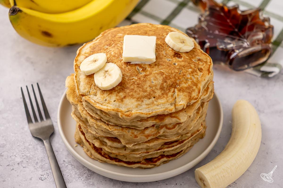 Une pile de crêpes au yaourt grec et à la banane.