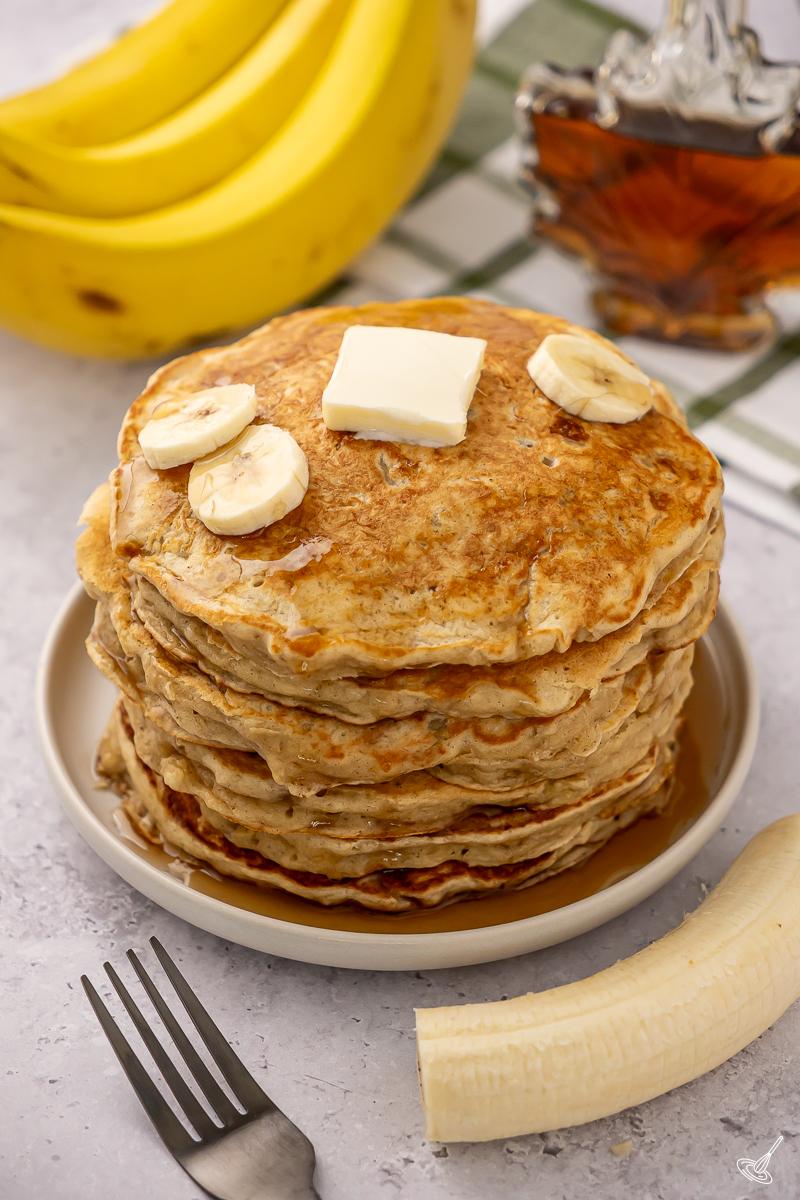 Une pile de crêpes au yaourt grec et à la banane.