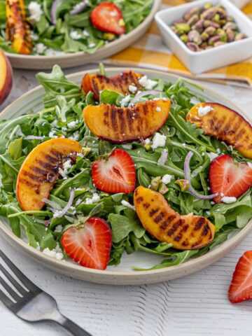Salade de pêches grillées et de roquette dans une assiette.
