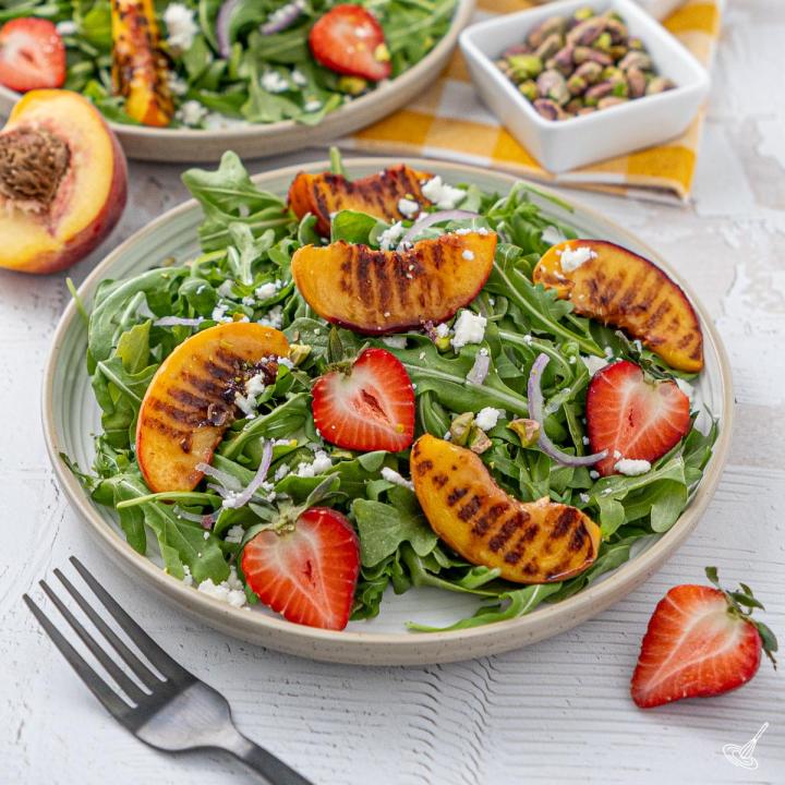 Grilled Peach and Arugula Salad on a plate.