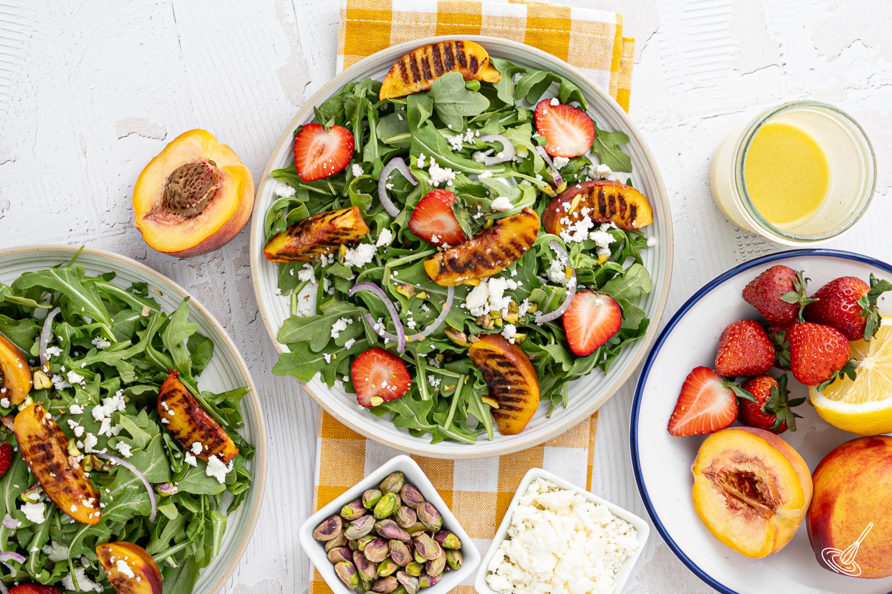 Plates of Grill Peach and Arugula Salad on the table.