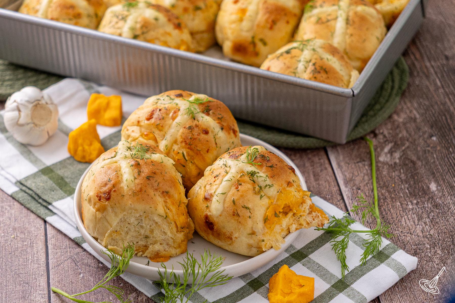 Cheddar Chive Hot Cross Buns on a plate.