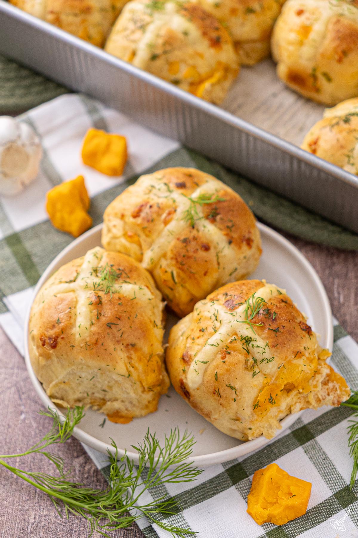Cheddar Chive Hot Cross Buns on a plate.