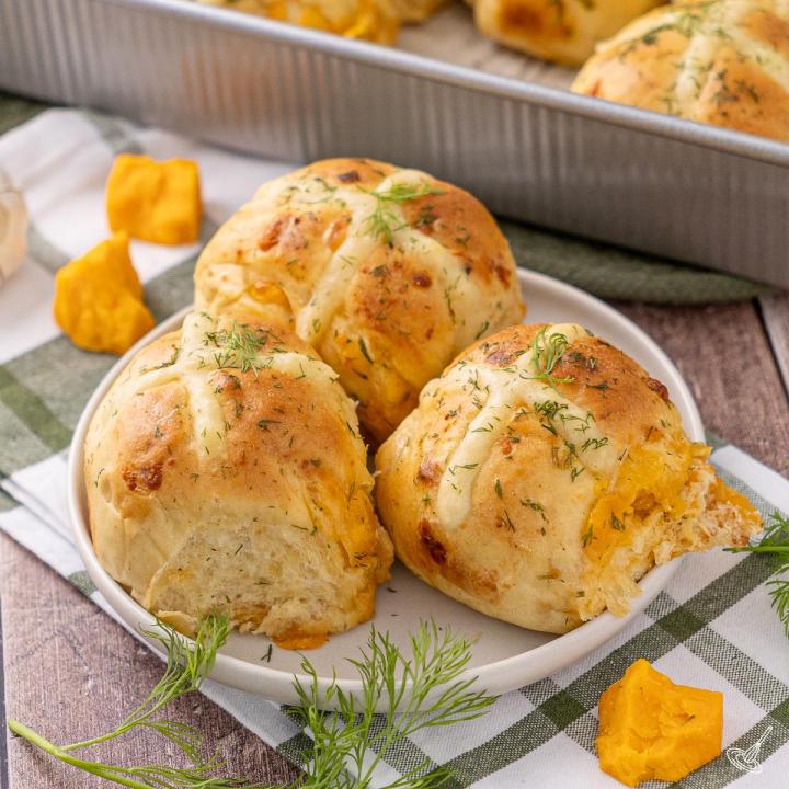 Cheddar Chive Hot Cross Buns on a plate.