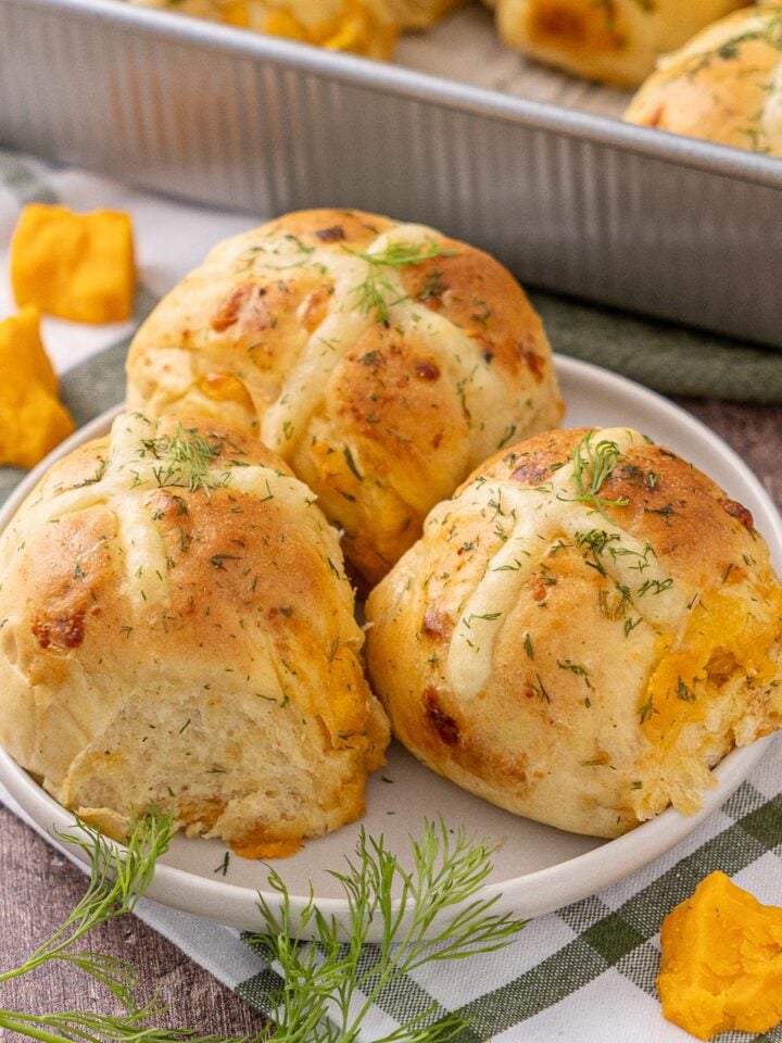 Cheddar Chive Hot Cross Buns on a plate.