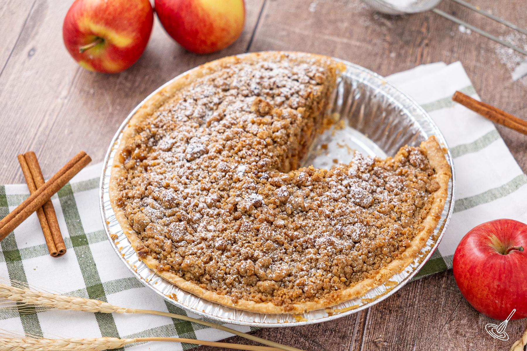 An Easy Freezer Apple pie on a table with a slice missing from it. 