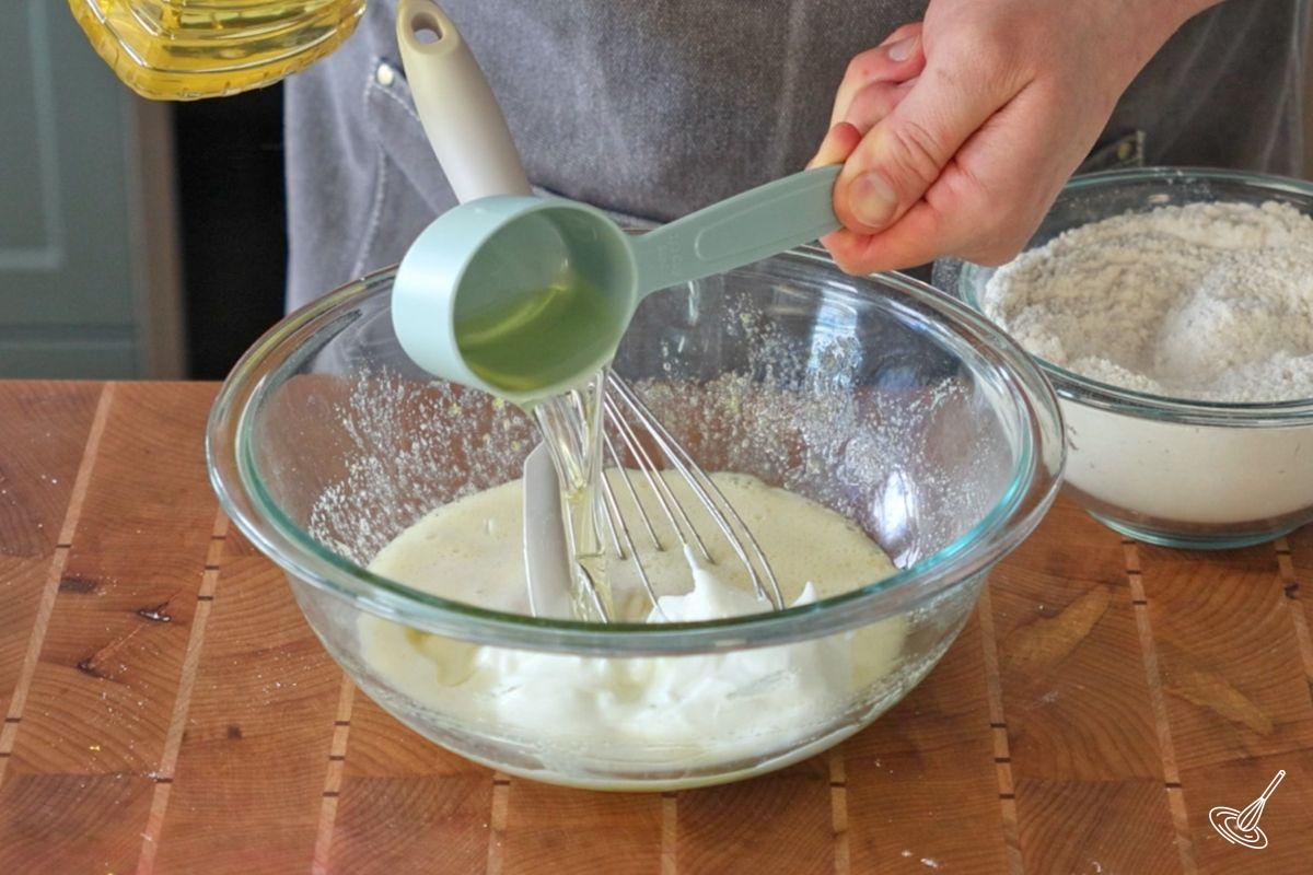 Quelqu’un fouette les ingrédients liquides dans un grand bol.
