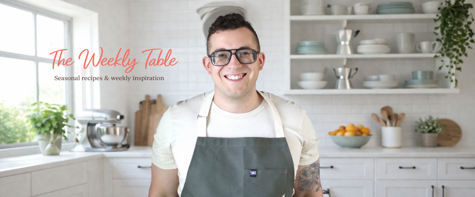 Alix from French Kiss Cook standing in his kitchen with the weekly table logo beside him. 