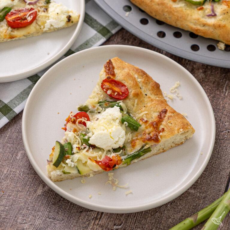 A slice of Primavera pizza on a plate.