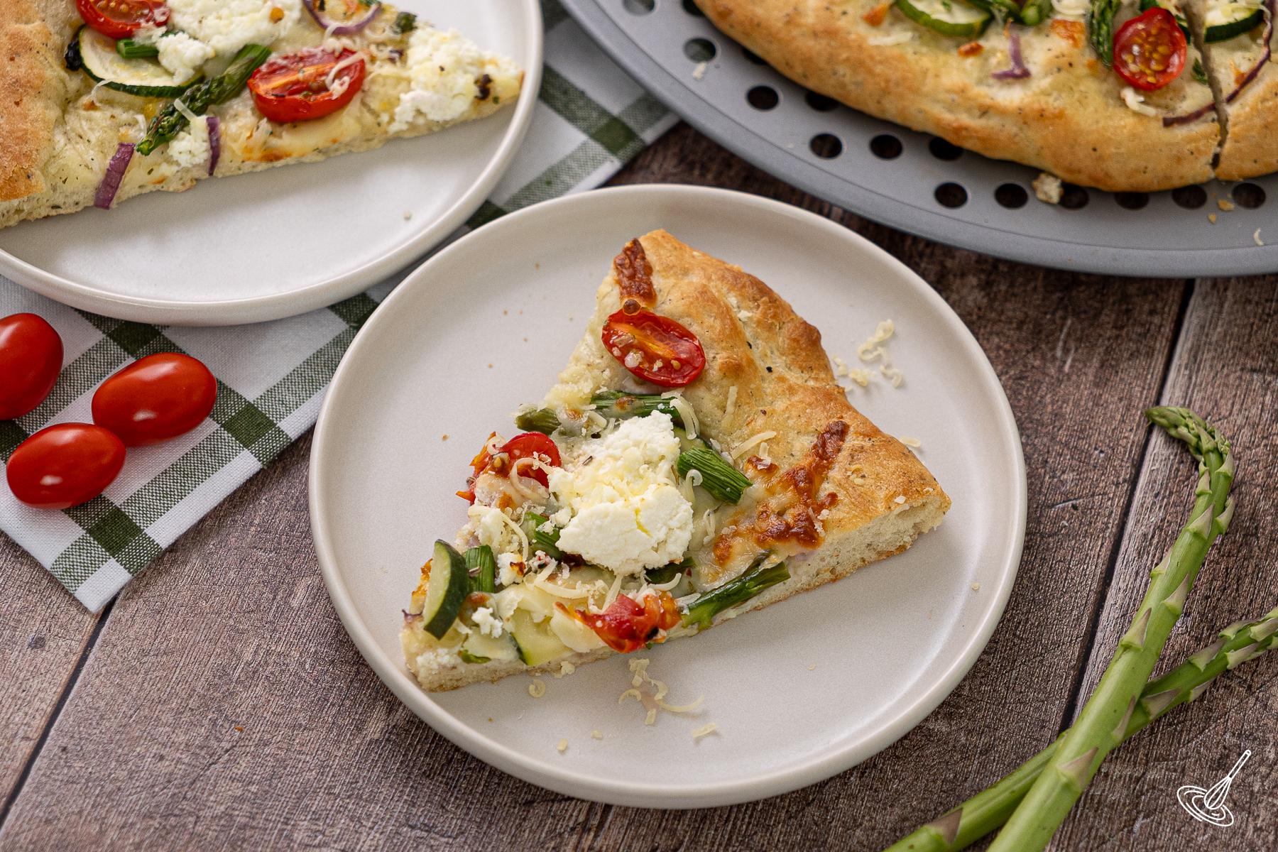 A slice of Primavera pizza on a plate.