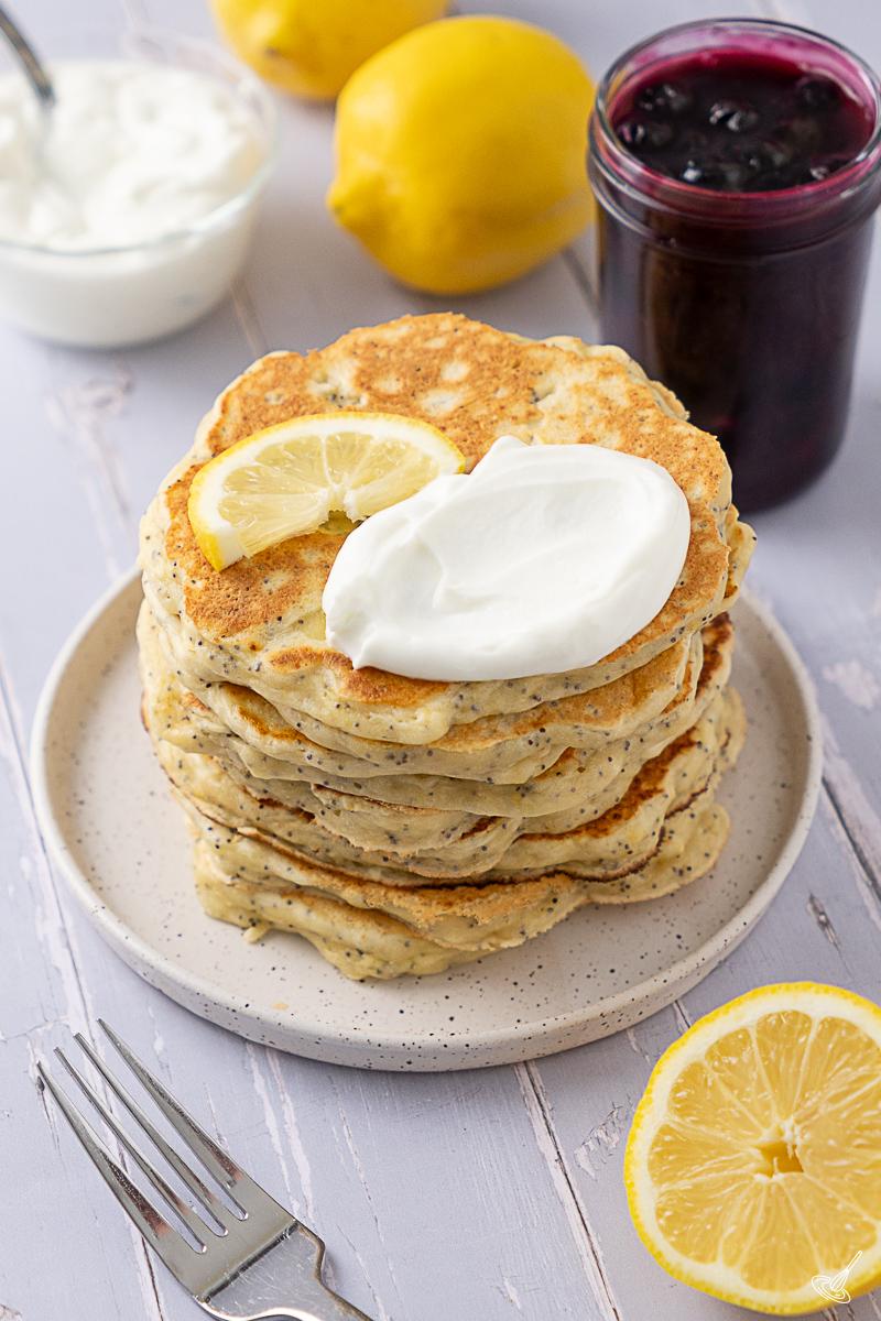 A stack of Lemon Poppy Seed Cottage Cheese Pancakes on a plate.