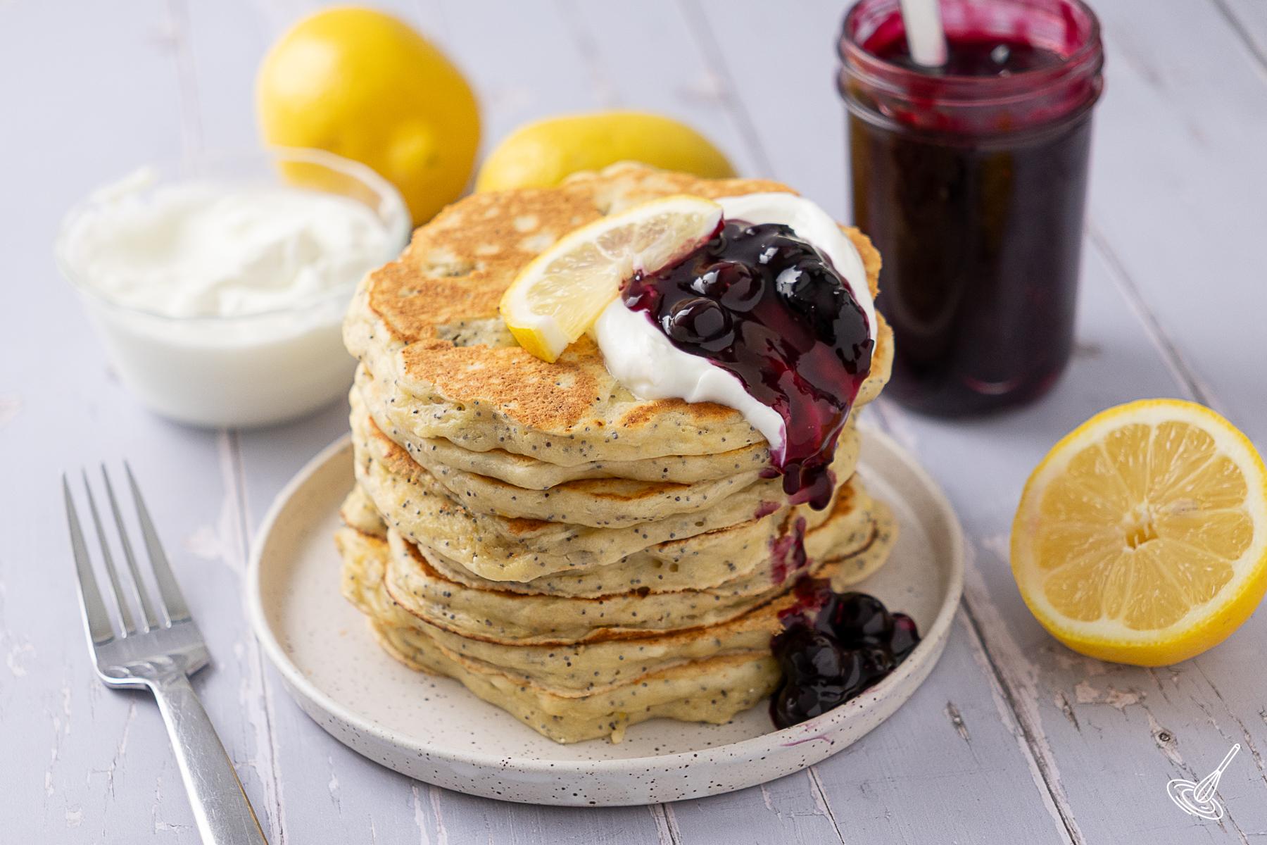 A stack of Lemon Poppy Seed Cottage Cheese Pancakes on a plate.