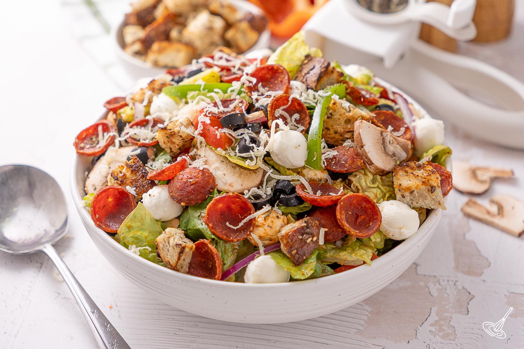 Deluxe Pizza Salad recipe in a serving bowl. 