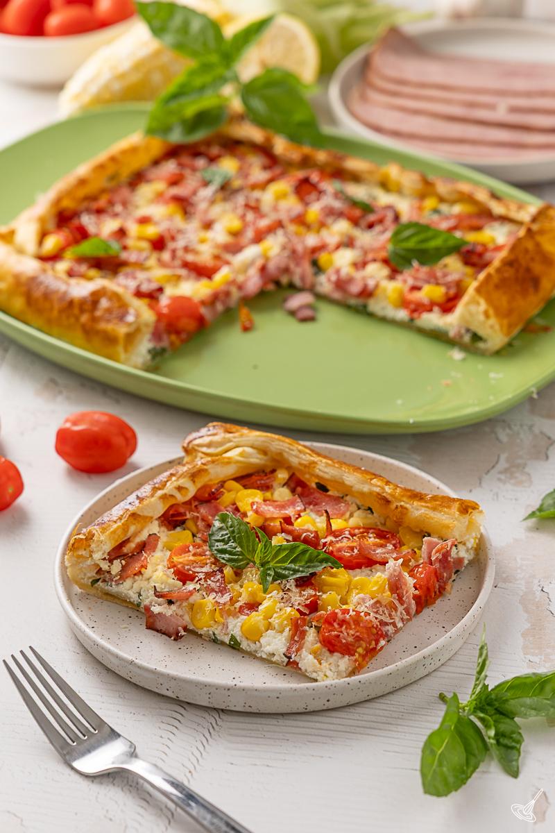 A slice of Sweet Corn, Tomato & Turkey Bacon Galette on a plate. 