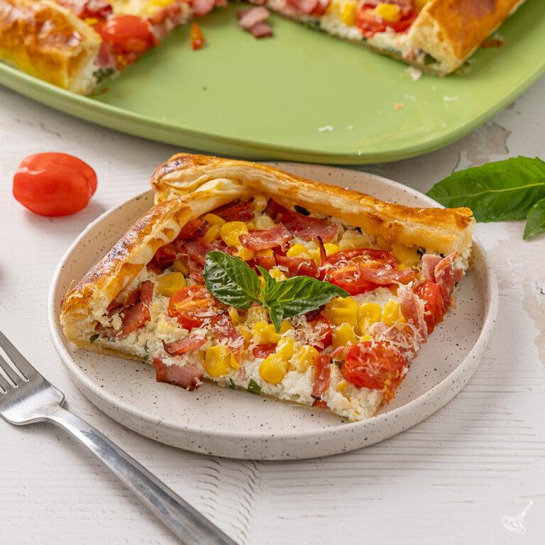 A piece of Sweet Corn, Tomato & Turkey Bacon Galette on a plate.