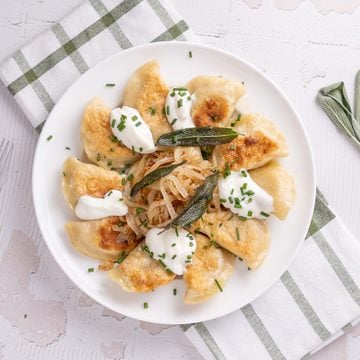 Pumpkin pierogies with brown butter and sage on a plate.