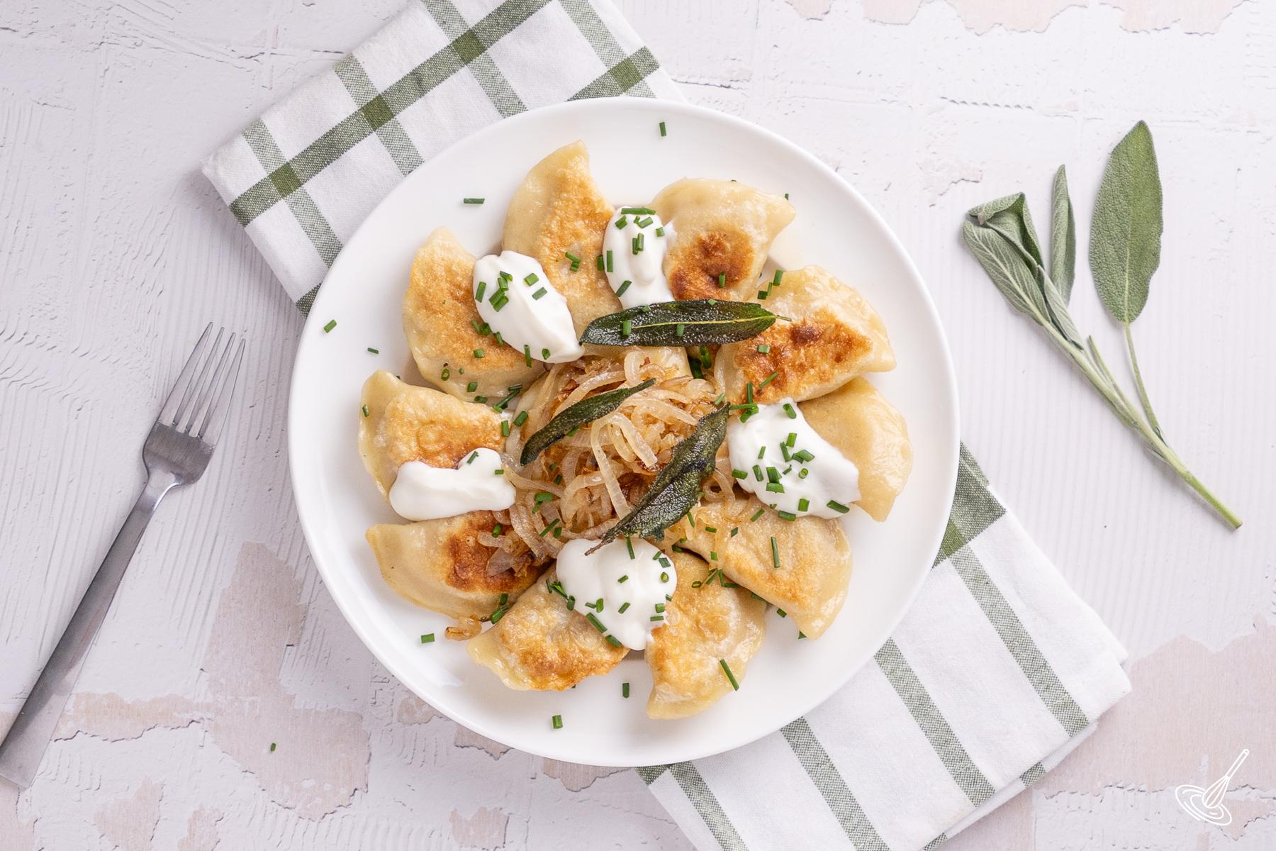 Pumpkin Pierogies with Brown Butter and sage on a serving plate.