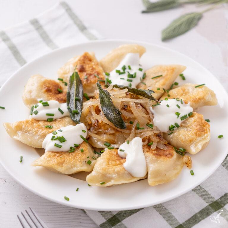 Pumpkin Pierogies with brown butter and sage on a plate.