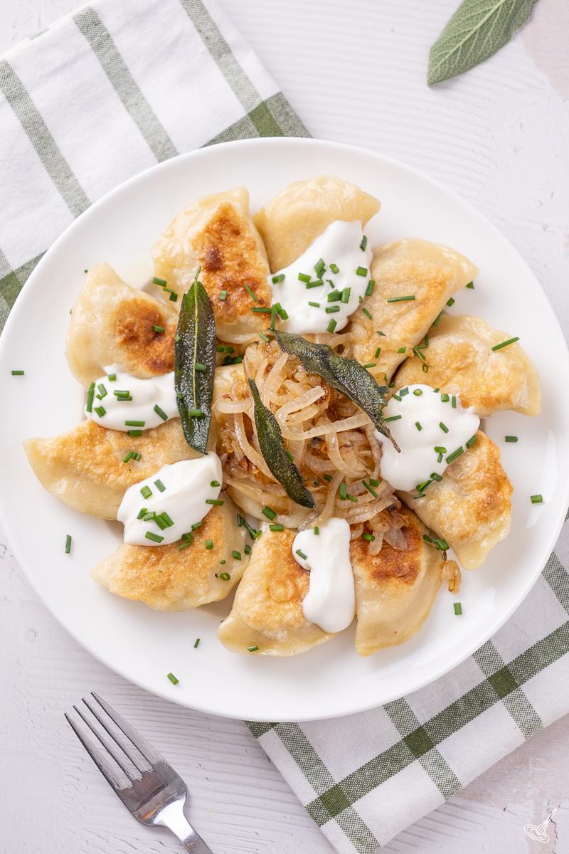 Pumpkin Pierogies with Brown Butter and sage on a serving plate. 